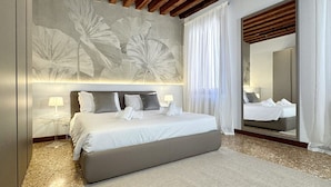 A modern bedroom with a large bed, a bedside table with a lamp, and a large mirror. - Residence Salieri (500mt. from St. Mark's Square) (Venecia)