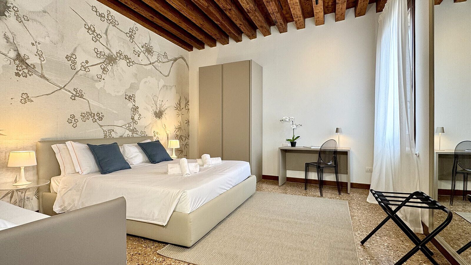 Ein Schlafzimmer mit Bett, Nachttischen, Schreibtisch und Stuhl.