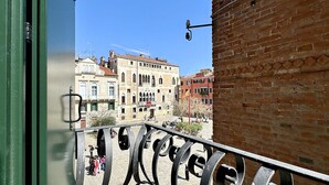 A balcony with a metal railing overlooking a street with historic buildings. - Residence Salieri (500mt. from St. Mark's Square) (Venecia)