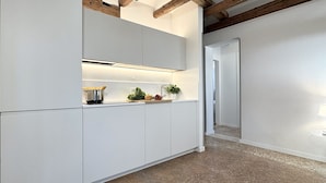 A modern kitchen with white cabinetry, a stainless steel sink, and a countertop with fresh produce and a pot of pasta. - Residence Salieri (500mt. from St. Mark's Square) (Venecia)