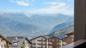 A mountain view with residential buildings, including a multi-story building with balconies and solar panels. - Eden Roc 6 - 4 pers - près des pistes (Haute-Nendaz)