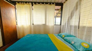 A room with a bed, curtains, and a window.