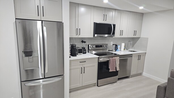 Una cocina moderna con electrodomésticos de acero inoxidable, microondas y horno empotrado.