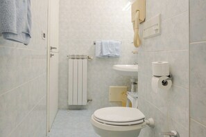A bathroom with a toilet, sink, and towel rack. - Hotel 3comfort and Serenity Heart of Ventimiglia (Ventimiglia)