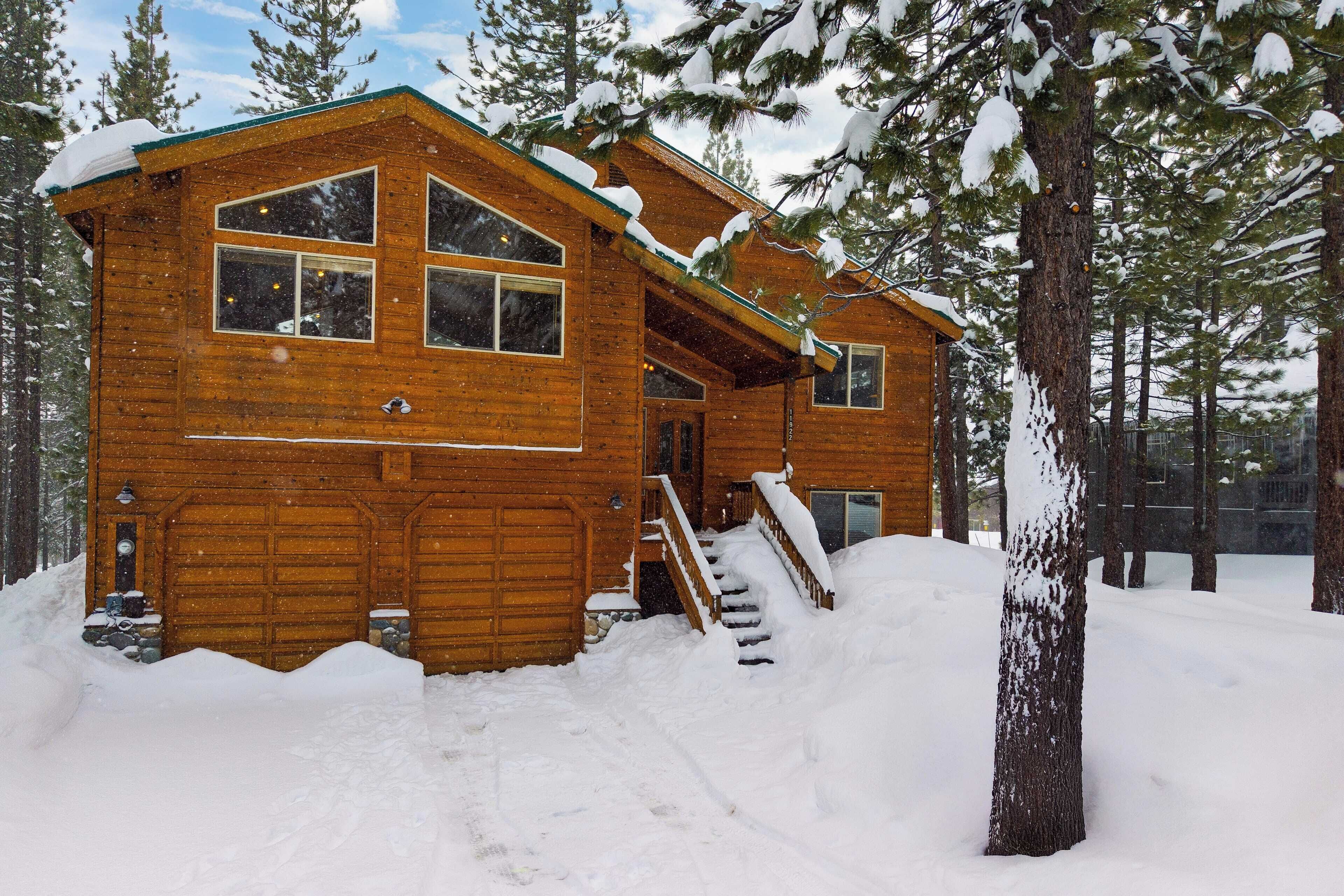 Une cabane en bois dotée d’un porche à l’avant et d’un escalier menant à l’entrée.