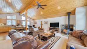 A spacious living area with a fireplace, leather sofas, a coffee table, and a television. - Oslo Haus by Avantstay Cabin Retreat Near Northstar + Downtown Truckee (Truckee)
