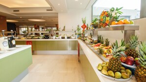 A buffet with a variety of fruits and vegetables, including pineapples, oranges, and apples, arranged on a counter. - Rhodos Horizon Marina (Rhodes)