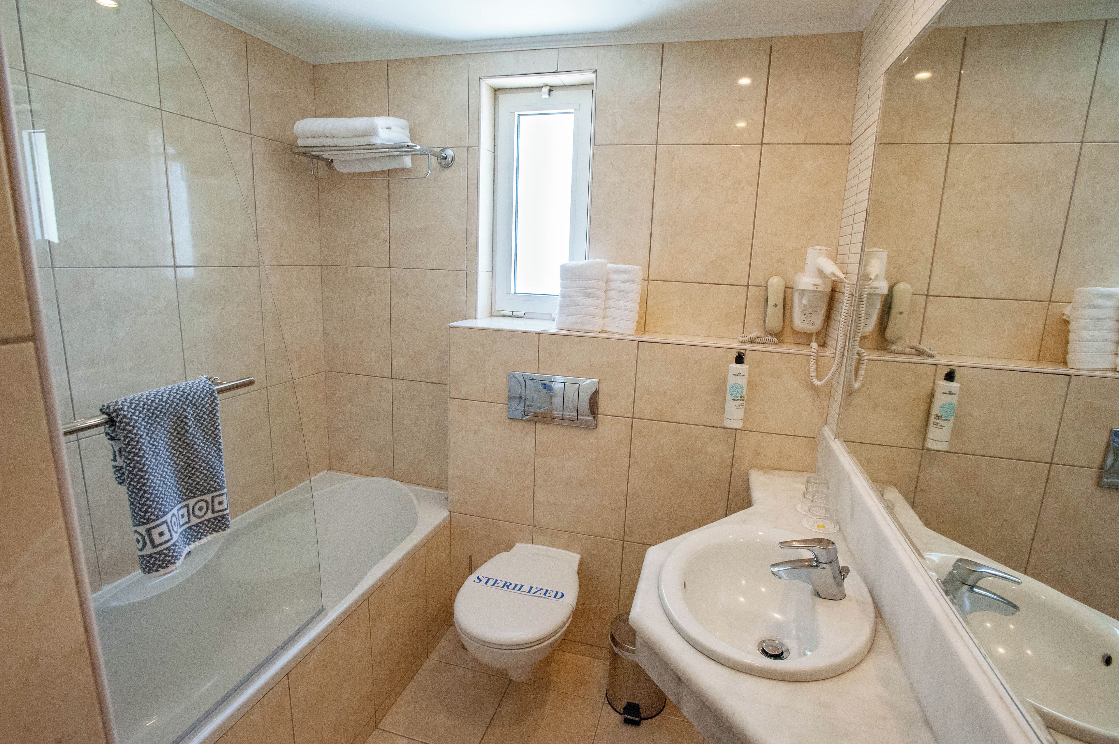 A modern bathroom with a bathtub, toilet, and sink.