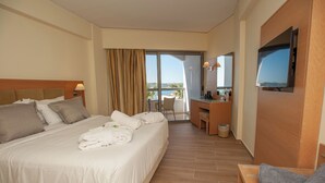 A hotel room with a bed, a desk, a TV, and a balcony with a view. - Rhodos Horizon Marina (Rhodes)