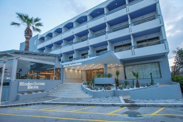 A multi-story hotel with balconies, a palm tree, and a sign reading "Rhodos Horizon Marina". - Rhodos Horizon Marina (Rhodes)