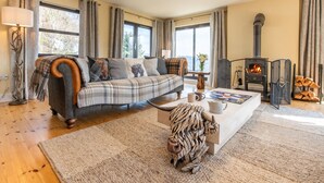 A cozy living room with a sofa, coffee table, and a fireplace. - Drover's Lodge by Interhome (Drumnadrochit)