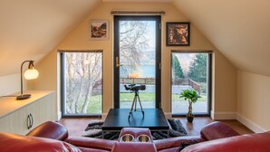 A cozy room with a large window, a tripod, and a potted plant. - Drover's Lodge by Interhome (Drumnadrochit)