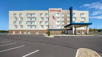 A Hampton Inn & Suites by Hilton building with a parking lot in front.