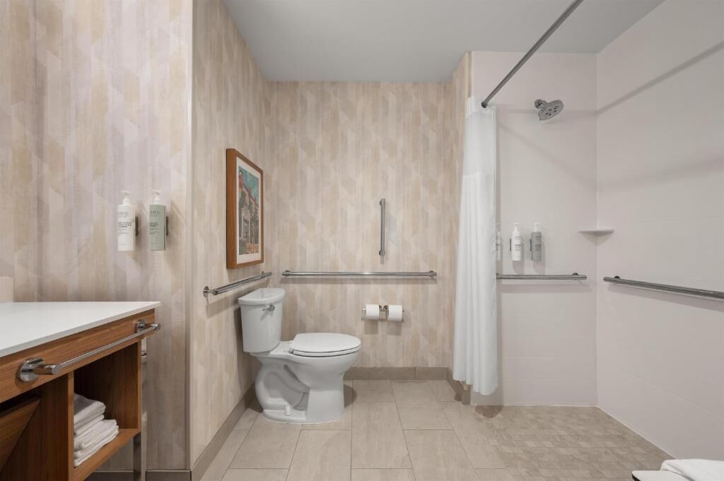 Een moderne badkamer met toilet, douche en wastafel.