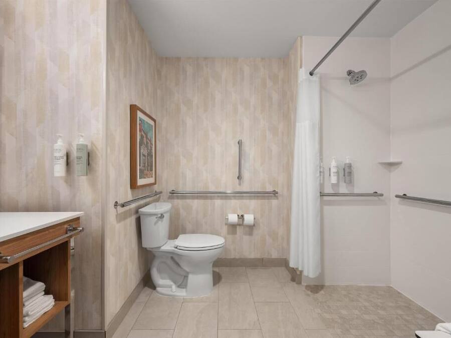 Een moderne badkamer met toilet, douche en wastafel.