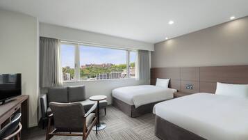 A hotel room with two beds, a TV, a desk, and a chair.