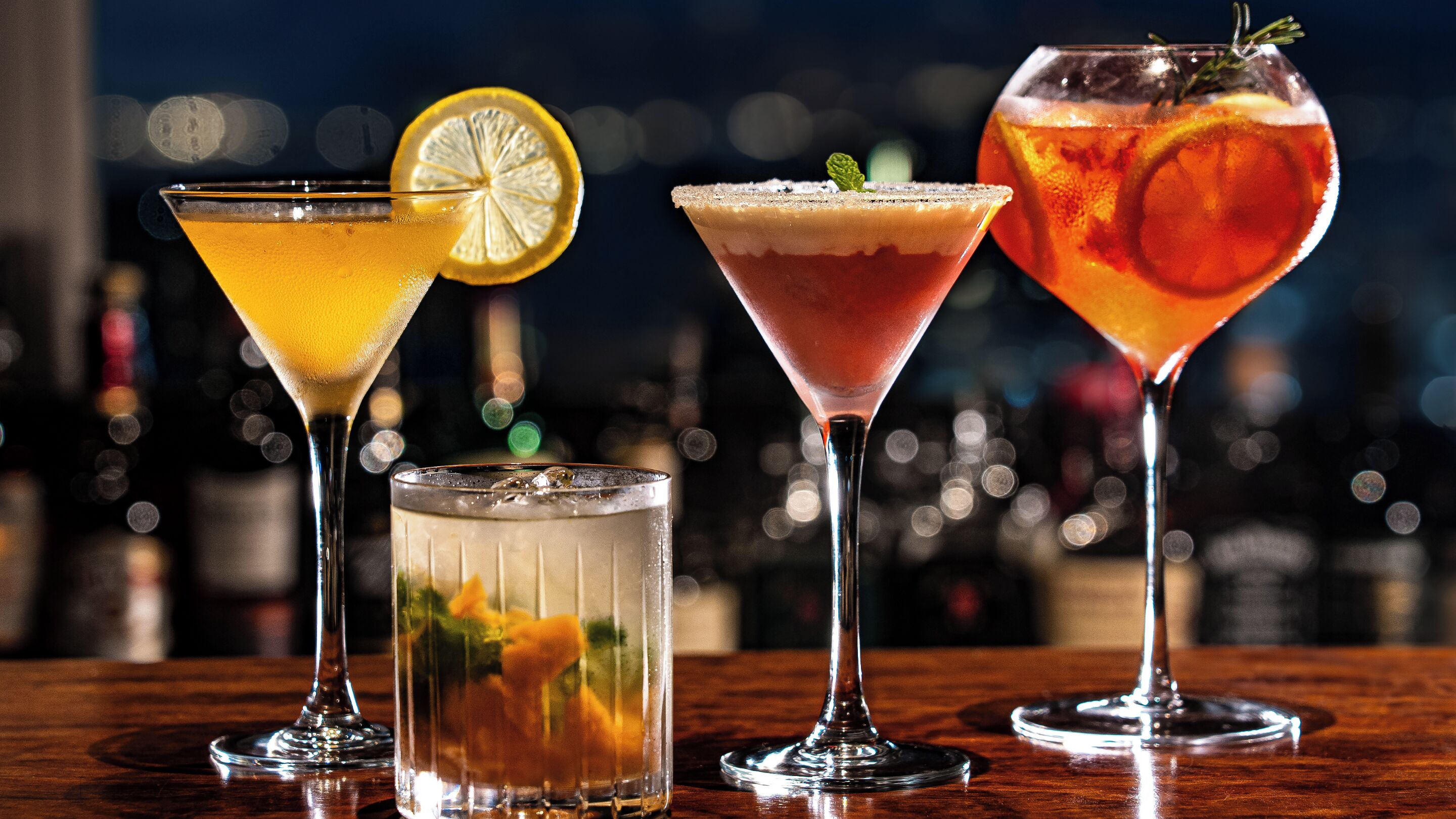 Four different cocktails on a bar counter.