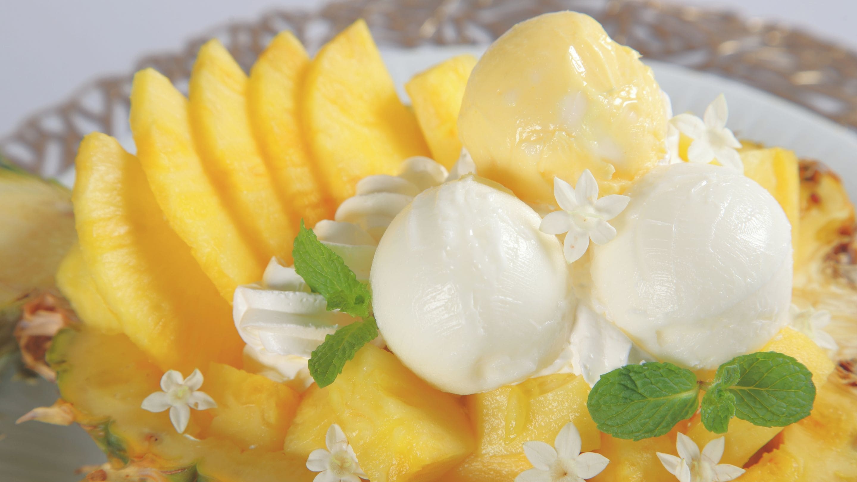 A dessert with mango slices and ice cream on a plate.