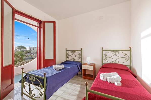 Une chambre avec deux lits, une fenêtre donnant sur un beau paysage et une table de chevet avec une lampe.