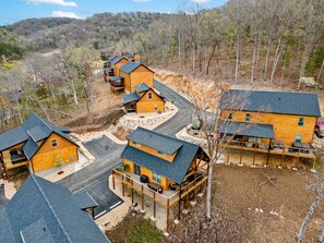 A cluster of wooden cabins with multiple decks, surrounded by a forested area. - Private Hot Tub with Deck, Water View, Near Table Rock Lake & Free Attraction Tickets (Hollister)