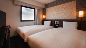 A hotel room with two beds, a TV, a window with curtains, and a wall-mounted light fixture. - Graces Hotels (Inzai)