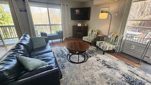 Relax in this stylish living room with a sofa, coffee table, and flat-screen TV.