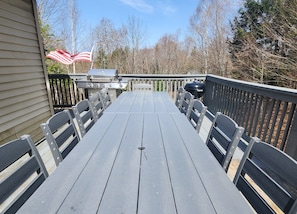 Enjoy al fresco dining on a spacious deck with a grill and comfortable seating.