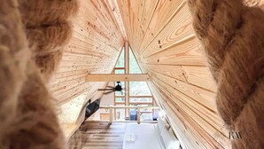 A wooden interior with a sloped ceiling and a view through a window. - Modern A-Frame-Hot Tub-Gaming Area-EV Charger-10 Minutes to Slade (Stanton)