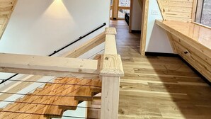 A wooden interior with a sloped ceiling, a staircase, and a window. - Modern A-Frame-Hot Tub-Gaming Area-EV Charger-10 Minutes to Slade (Stanton)