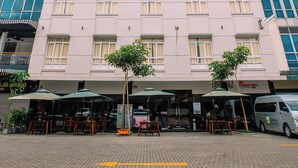 A hotel with a sign reading "QUADRANT HOTEL" and a parked van in front. - The Quadrant Hotel KNO (Medan)