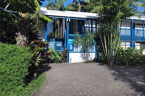 A building with a blue gate, a paved entrance, and surrounding greenery. - Mission Beach Lodge (Mission Beach)