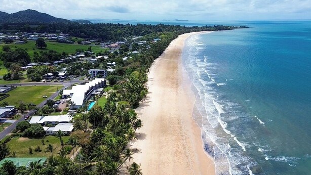 An aerial view of a coastal area with a sandy beach, a residential neighborhood, and a clear view of the ocean. - Mission Beach Lodge (Mission Beach)