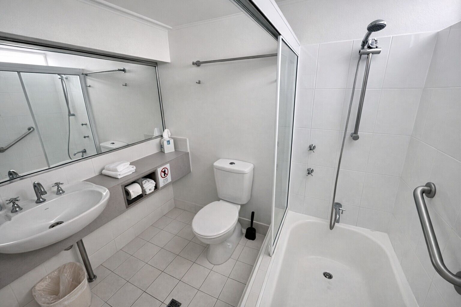 Un baño con lavamanos, inodoro y ducha.
