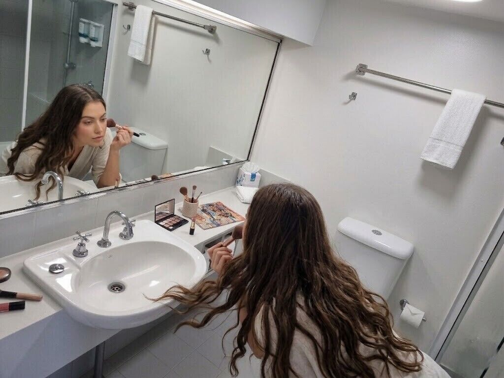 A bathroom with a sink, mirror, and toiletries.