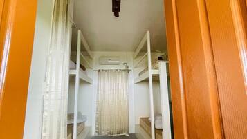 A narrow hallway with bunk beds, a door, and a curtain.