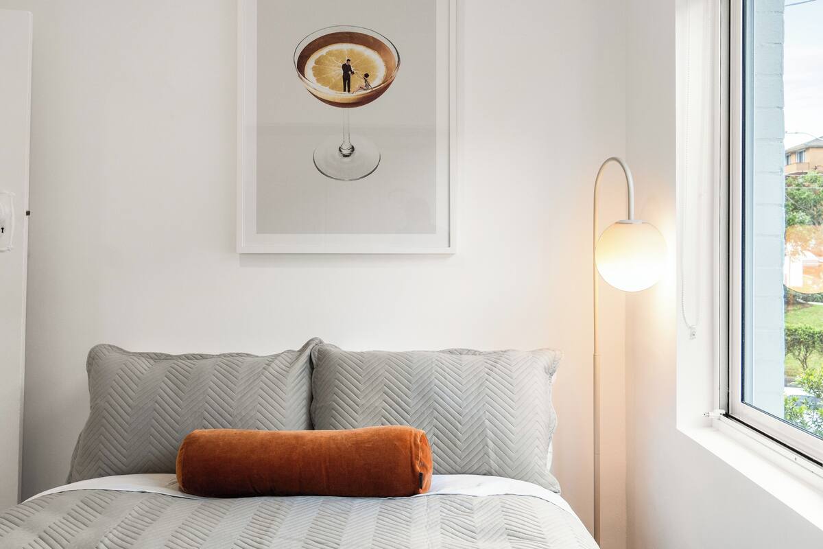 Un dormitorio con cama, un cuadro en la pared y una ventana con vistas.