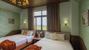 A hotel room with two beds, a large window, a chandelier, and wall-mounted lamps.