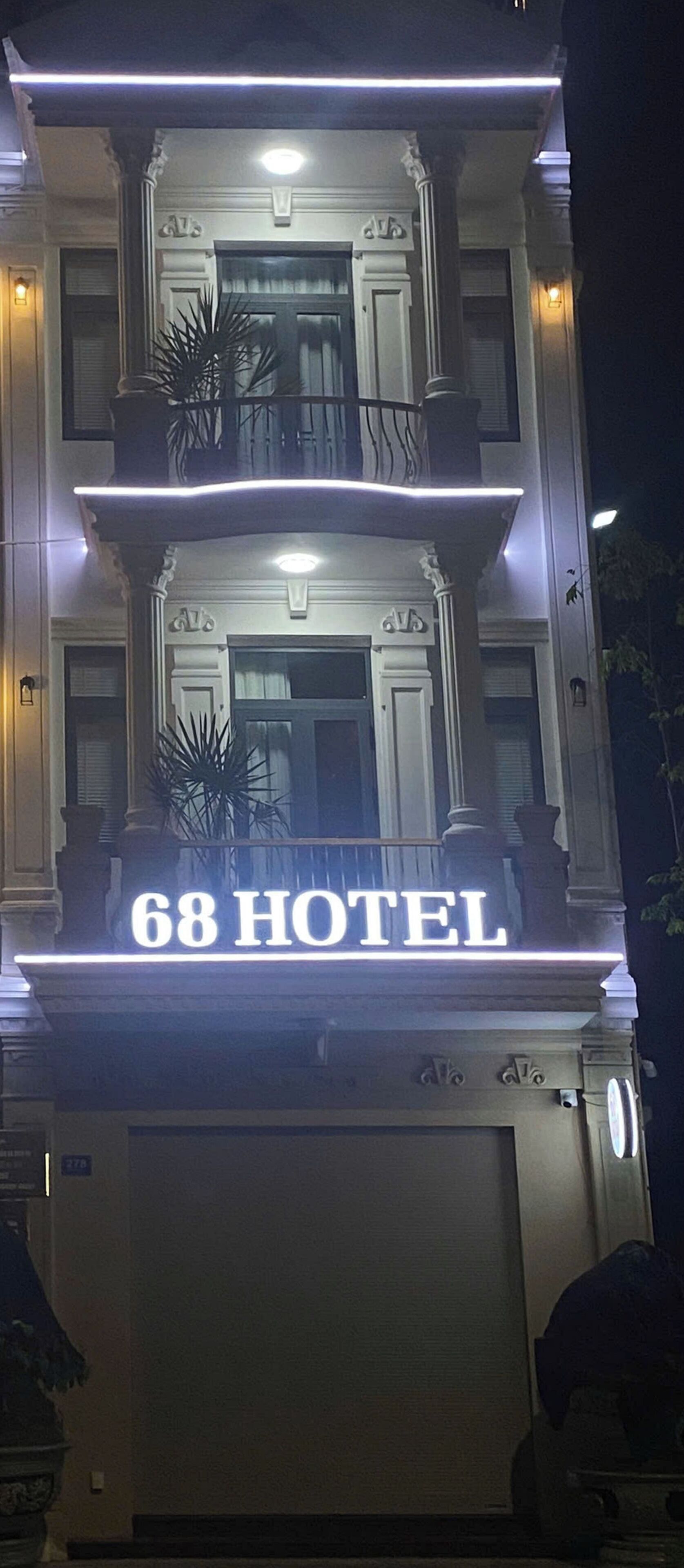 A hotel sign with "68 HOTEL" illuminated.