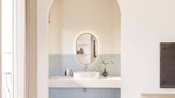 A bathroom with a white sink, a mirror, and a tiled floor.