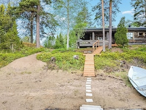 A wooden staircase leading to a cabin surrounded by trees.