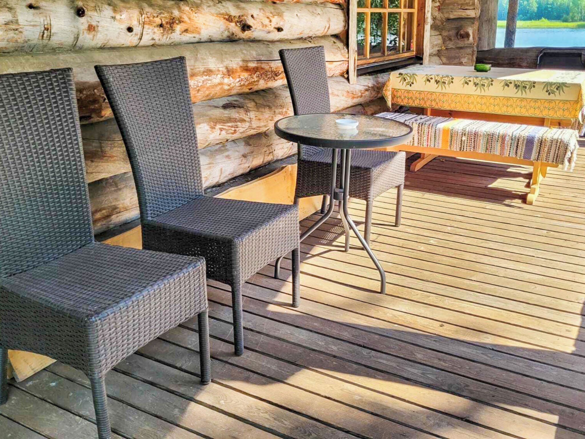 Eine Holzterrasse mit Korbmöbeln und einem Tisch.