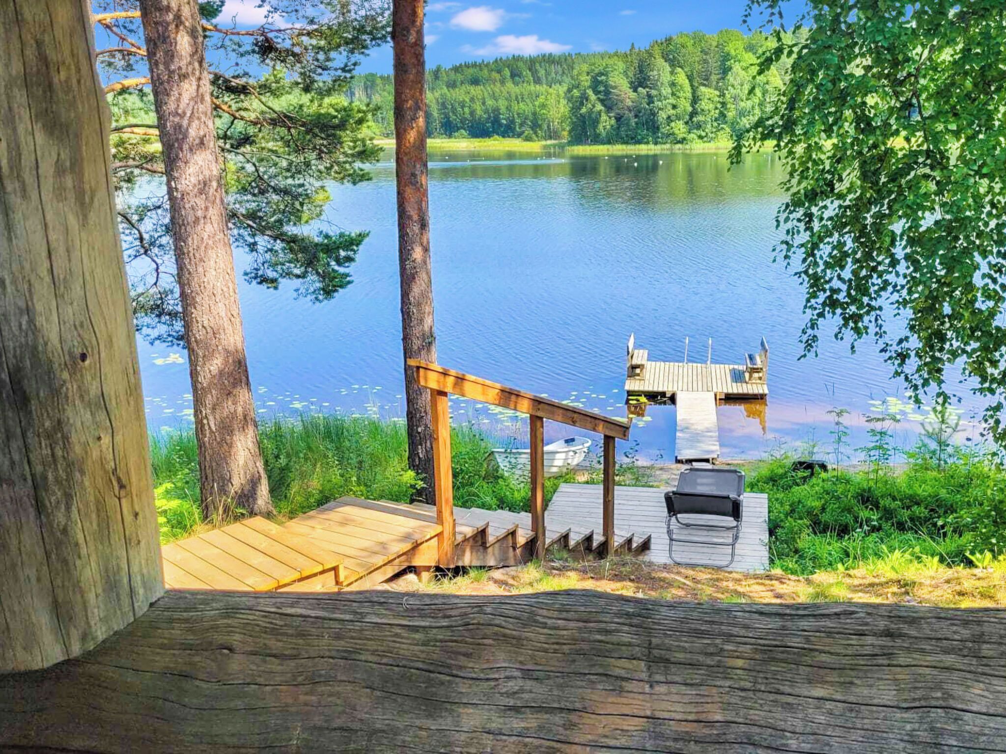 A wooden deck with a grill and a boat dock.