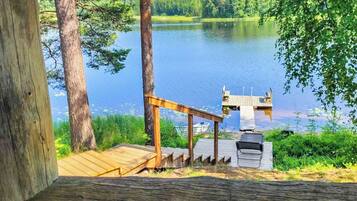 A wooden deck with a grill and a boat dock.