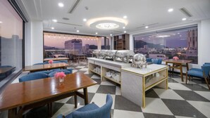 A modern restaurant with a checkered floor, round tables, and blue chairs.