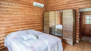Une chambre à coucher comprenant un lit, une armoire et un appareil de climatisation.