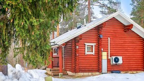 A red log cabin with a front porch, a small window, and an air conditioning unit. - Rustholli 1 by Interhome (Tampere)