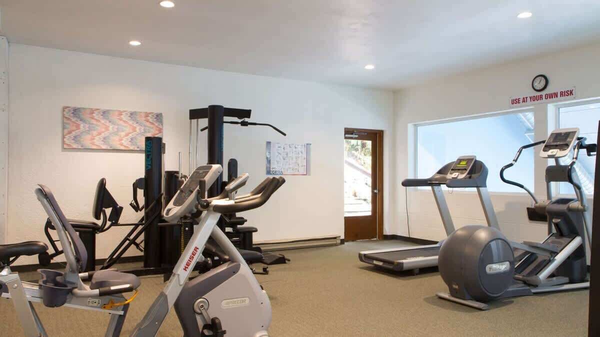 A gym with treadmills, elliptical machines, and weight equipment.