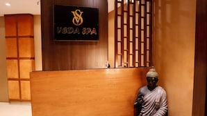 En receptionsdisk med träpanel och en skylt med texten ”VEDA SPA”.