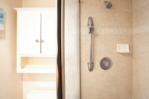 Ein Badezimmer mit Dusche, Toilette und einem Schrank.
