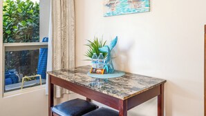 A dining table with a marble top, a blue decorative piece, and a small plant.